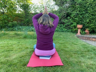 A woman performing yoga at garden